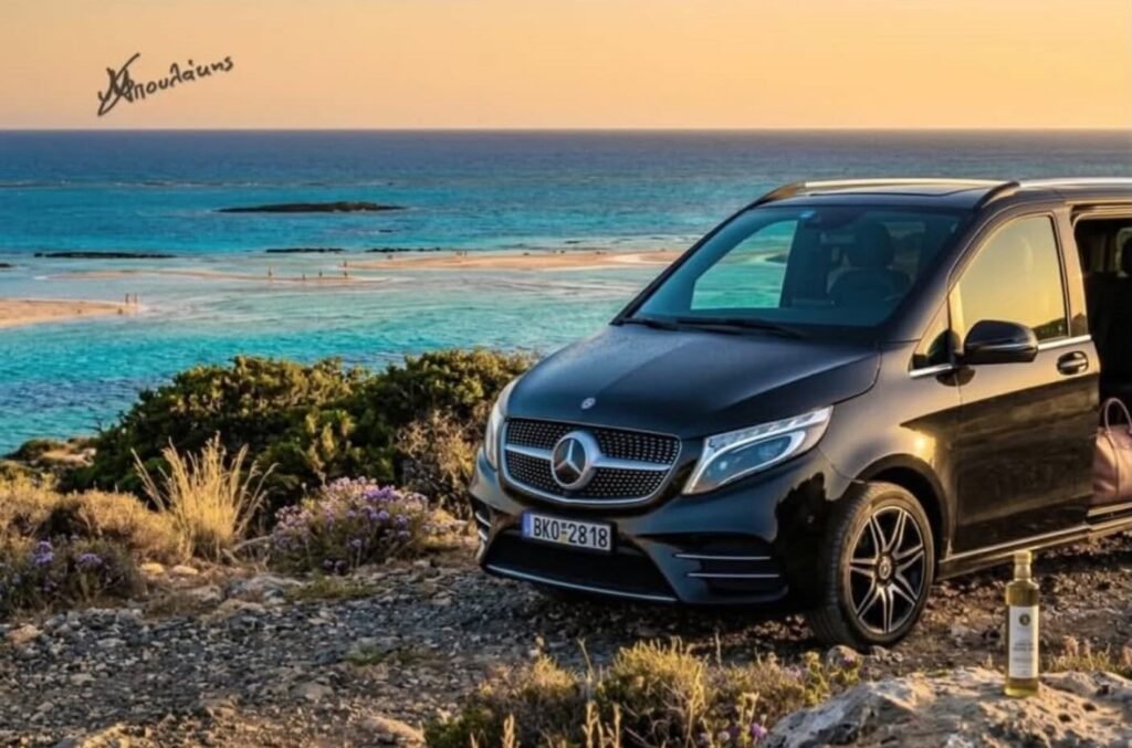 Black Mercedes V-Class with its door open above Balos lagoon at sunset